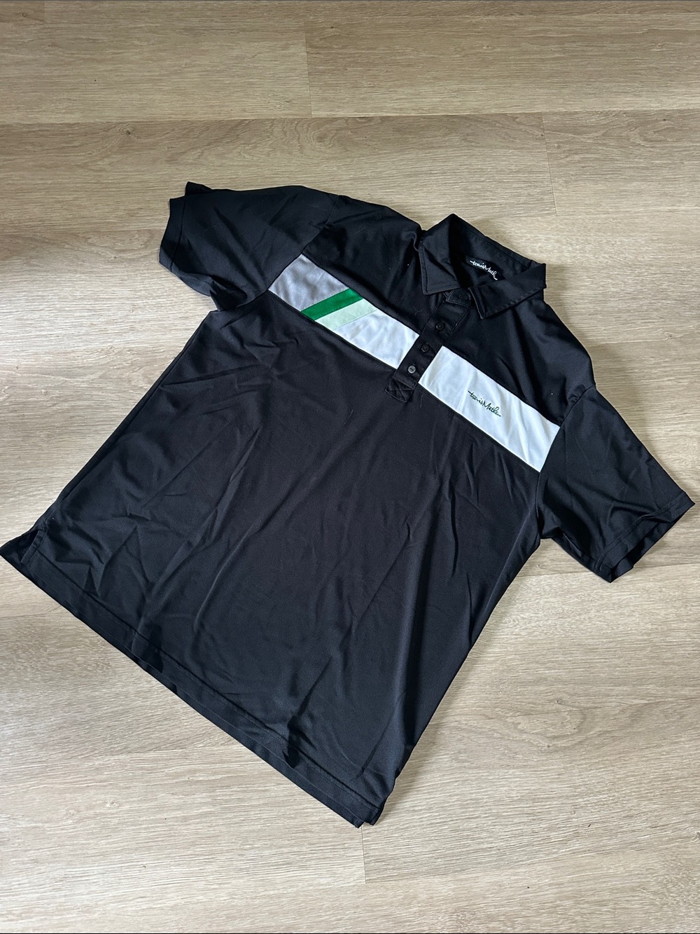 Travis Mathew Black Polo with White Chest Panel and Green Stripe